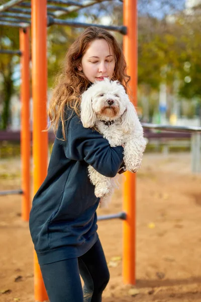 Chica haciendo ejercicios con un perro en sus manos — Foto de Stock