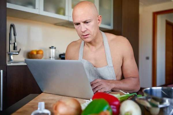 Man cooking with help of recipe on tablet. — Stock Photo, Image
