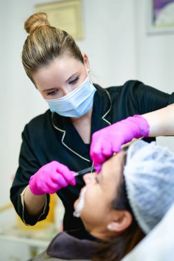 Elinde şırıngayla güzellik uzmanı portresi. Kozmetik uzmanı tıbbi aletleri tutuyor. Güzellik kliniği ya da hastane. Hemşire iğneyi yapacak.