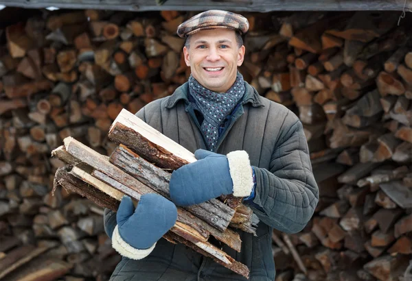 Muž nesoucí dřevo — Stock fotografie