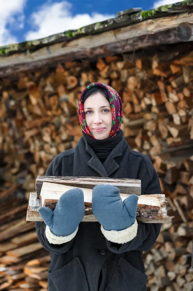 Vrouw in etnische kostuum met brandhout — Stockfoto