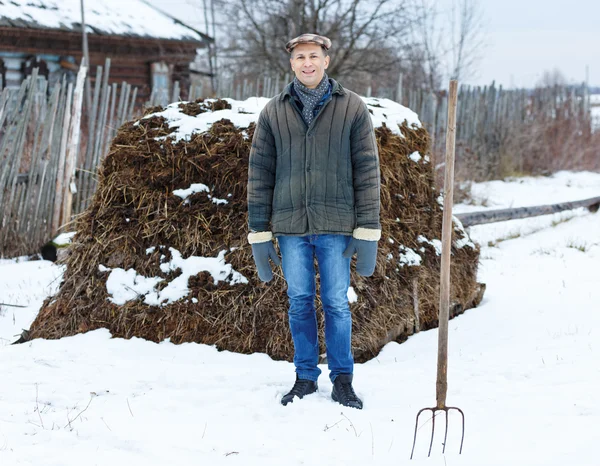 Bonde i högen av gödselmedel — Stockfoto