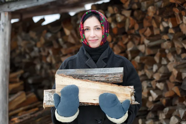 Frau in ethnischer Tracht mit Brennholz — Stockfoto