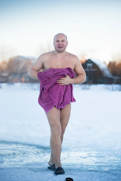 Радостный человек вытирает полотенце после купания в холодную зиму — стоковое фото