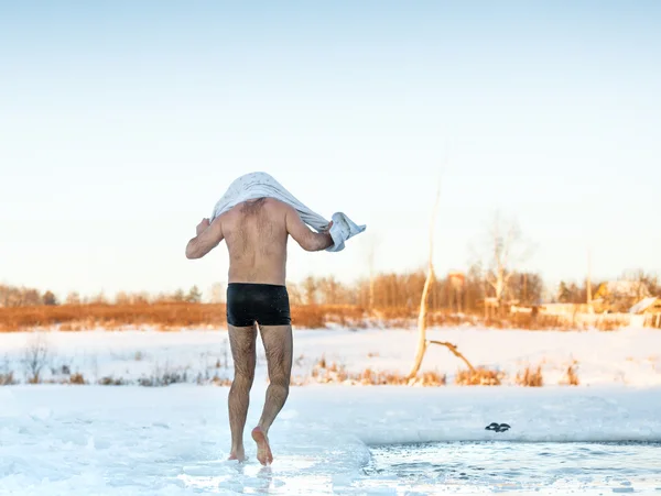 Hombre limpia toalla después de nadar en el agujero de congelación —  Fotos de Stock