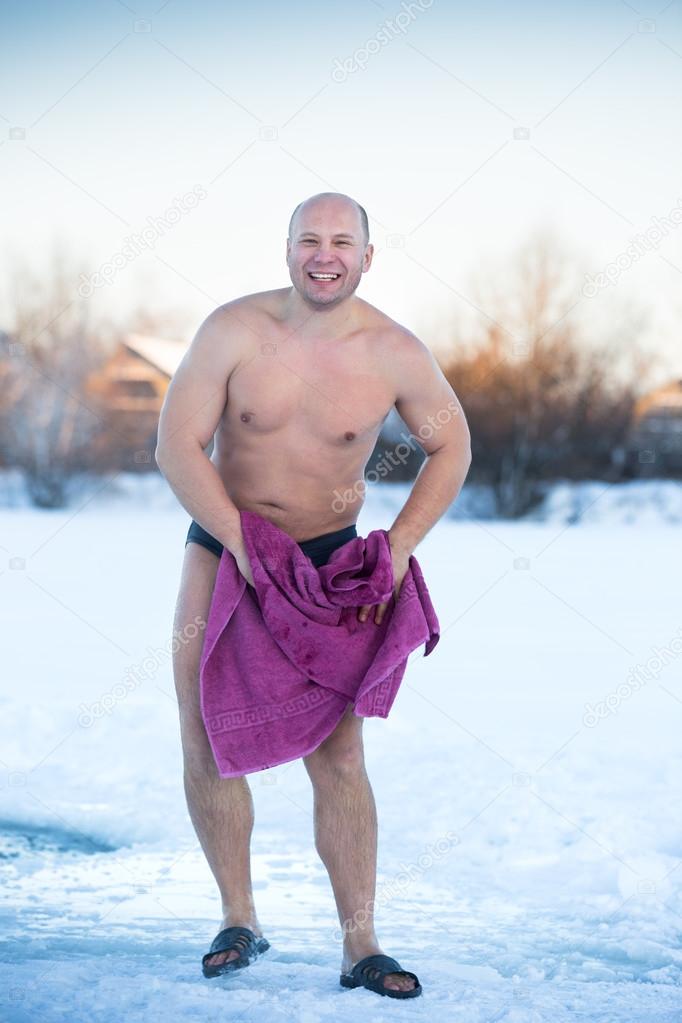 man wipes towel on  cold day outdoors