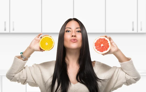 Brunette meisje met een citrus in keuken — Stockfoto