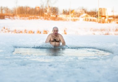 Kış yüzmesi. Buz deliğindeki adam.