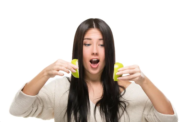 Funny girl looks at cut up green apple — Stock Photo, Image