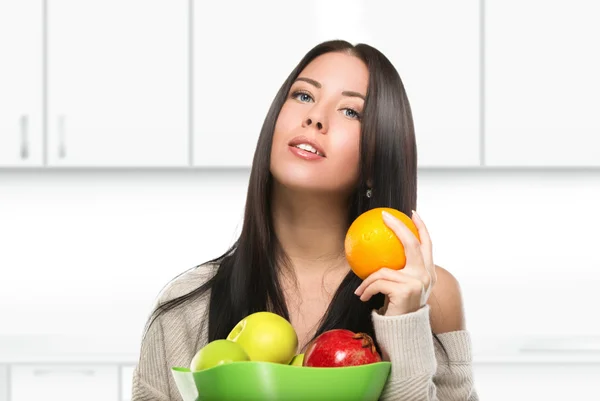 Attraktive brünette Frau mit Schüssel Obst in der Küche — Stockfoto