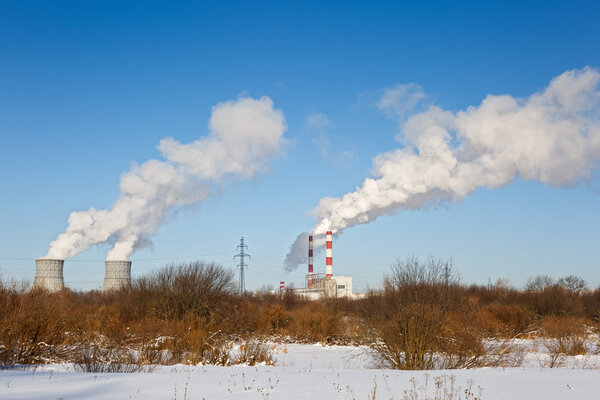 industrial park with chimney and white smoke on blue sky