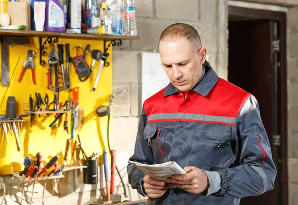 Mechanic worker studying his instructions — Stock Photo, Image