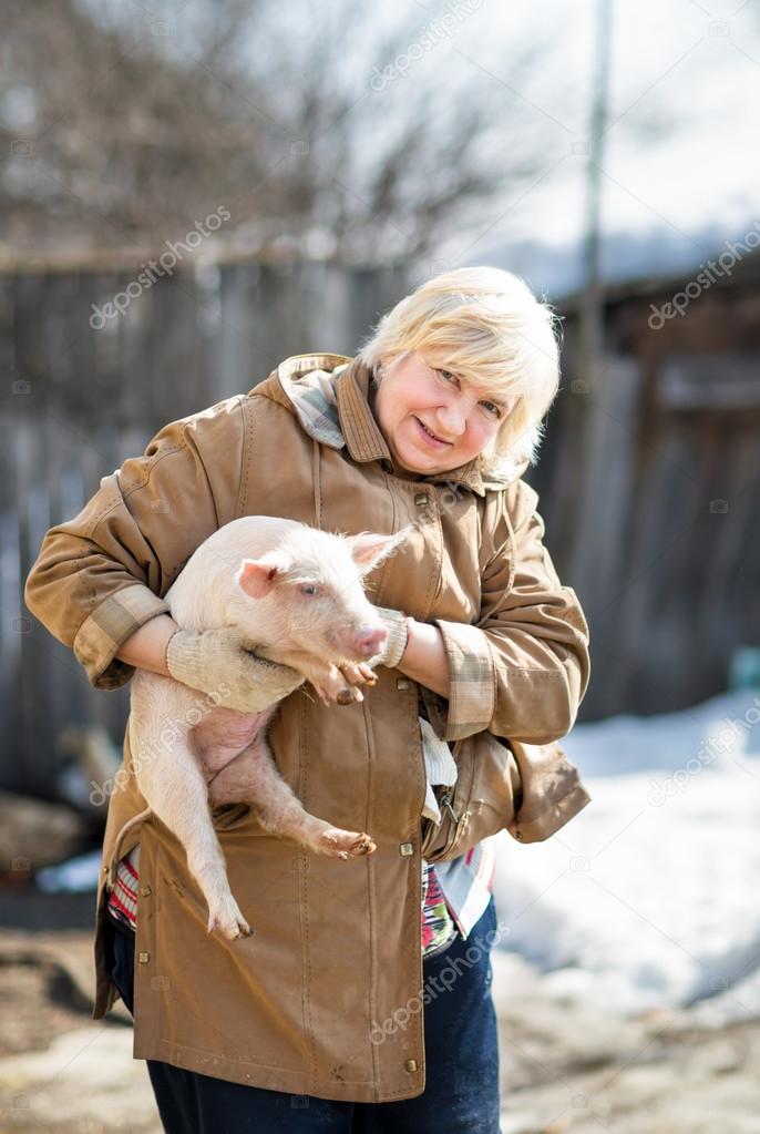 female farmer holding  pig