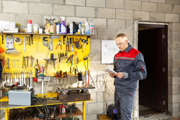 Mekanisk arbetare studera hans instruktioner — Stockfoto