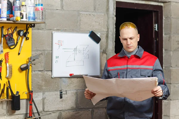 Mechanic worker studying his instructions — Stock Photo, Image