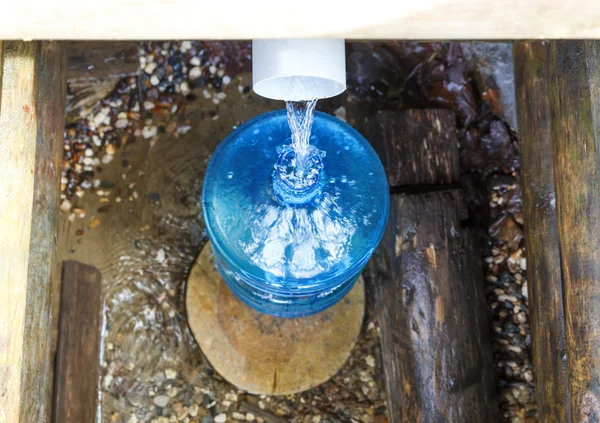 Zdroj láhev vody na jaře — Stock fotografie