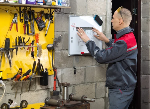 Mechanic worker studying his instructions — Stock Photo, Image