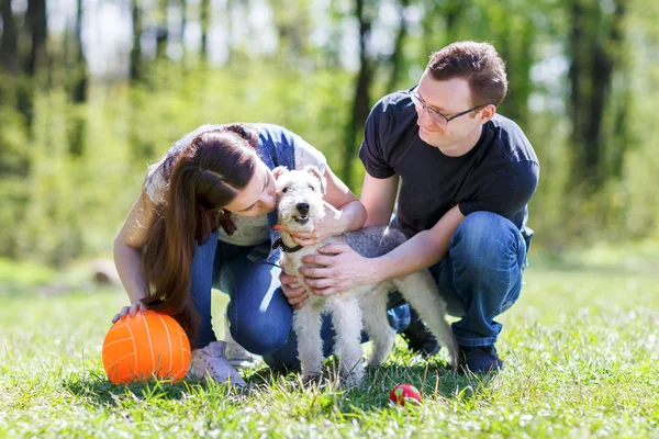 Feliz jovem casal e cão — Fotografia de Stock