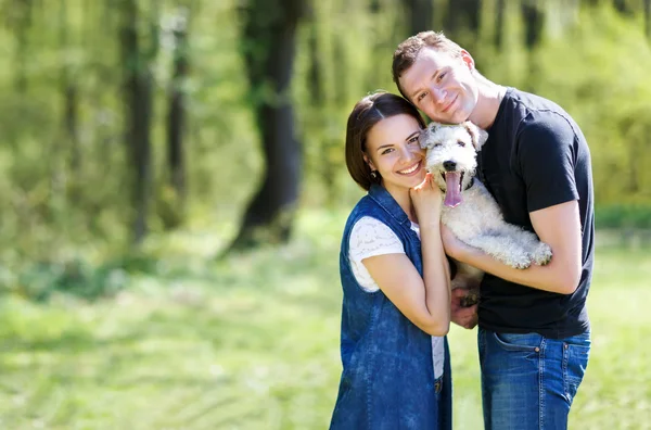 Feliz jovem casal e cão — Fotografia de Stock