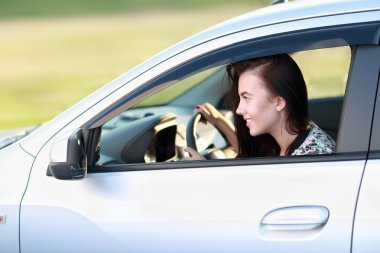 Araba süren genç bir kadın.