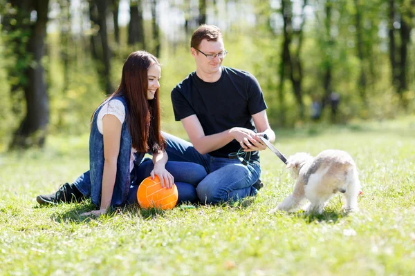 Счастливая молодая пара и собака — стоковое фото
