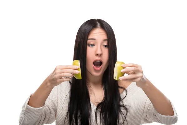 Funny girl looks at cut up  apple — Stock Photo, Image