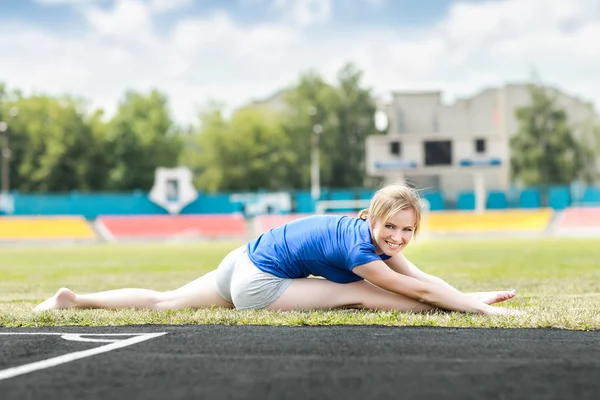 Beautiful woman doing core workout at a stadium — Stock Photo, Image