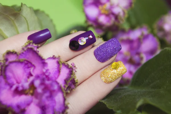 Manicure in de kleuren van viooltjes. — Stockfoto