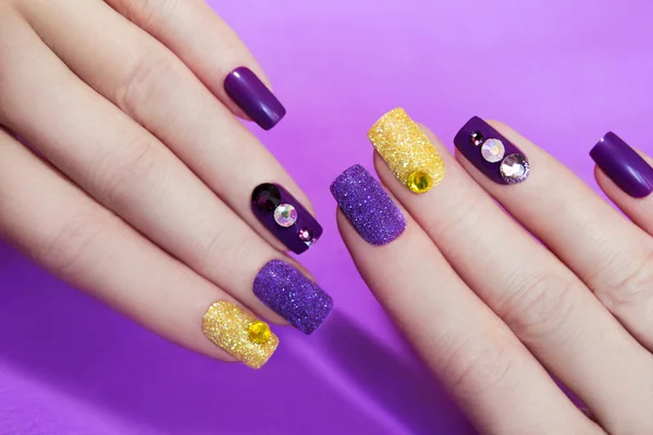 Lilac purple manicure with gold glitter. — Stock Photo, Image