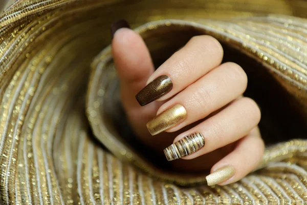 マットでファッショナブルなマニキュア爪の黄金の色長い爪の形でポーランドと茶色 — ストック写真