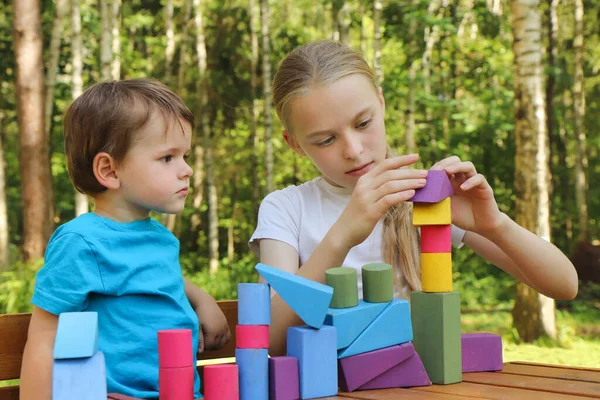 Una Chica Juega Con Niño Pequeño Cubos Colores Naturaleza Verano — Foto de Stock