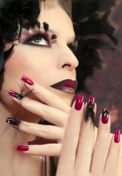 Burgundy manicure with feathers. — Stock Photo, Image