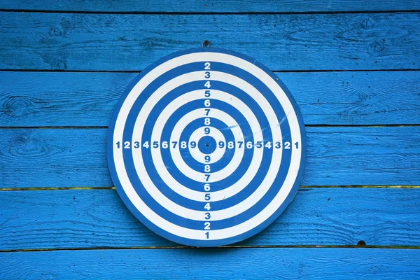 Target dartboard on old blue wooden plank — 스톡 사진