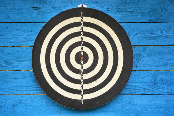 Target dartboard on old blue wooden plank