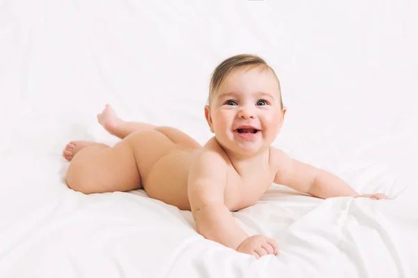 Beyaz yatakta yatarken çıplak sürpriz bebek kız
