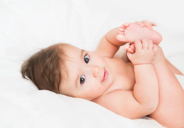 Glückliches Baby liegt auf dem Bett — Stockfoto