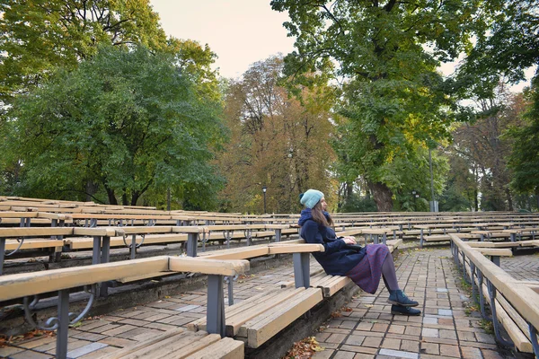 Meisje zit in het park — Stockfoto
