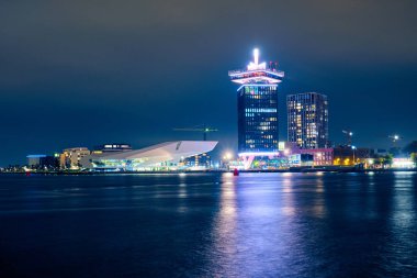 Geceleri Amsterdam 'da körfezin kıyısındaki modern binalar