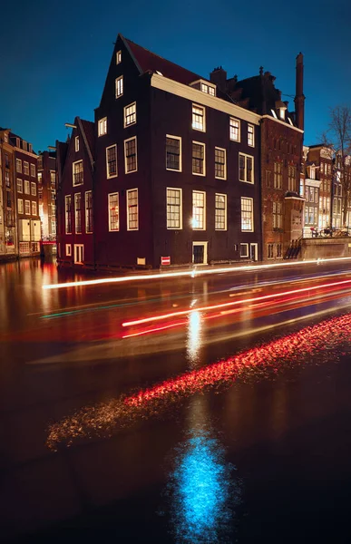 夜晚在阿姆斯特丹 一艘沿着运河航行的船的光迹 — 图库照片