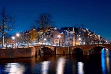 Şehir manzarası. Geceleri Amsterdam 'da kanal kenarındaki eski tuğladan evler..
