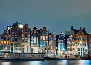 Night view of the dancing houses by the canal in Amsterdam.