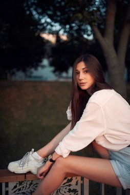 Gün batımında bir yaz parkında tatlı ve genç bir esmer