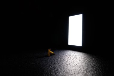 Bir adam büyük beyaz bir ekranın önünde oturuyor. Tamamen karanlıkta bir akıllı telefonun.