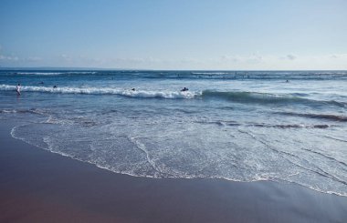 Canggu, Bali, Endonezya - 11 Ocak 2019: Sörfçüler Pantai Batu Bolong 'un yanında Hint Okyanusunda sörf yapıyorlar