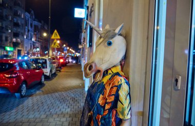 Polonya, Krakow - 1 Aralık 2019: Manken gece sokakta maske takıyor.