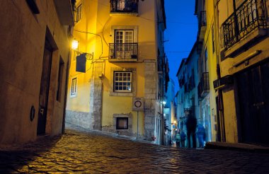 Lizbon 'un eski bölgesinin dar sokakları geceleyin.