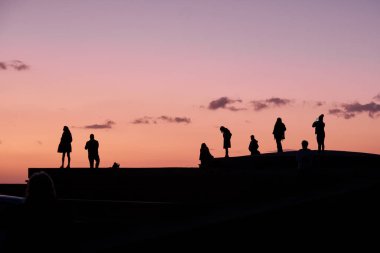 Gün batımında gökyüzündeki insanlar.