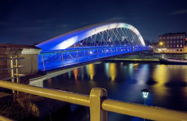 Peder Bernatek 'in Vistula Nehri üzerindeki köprüsü Polonya' nın Krakow şehrinde gece..