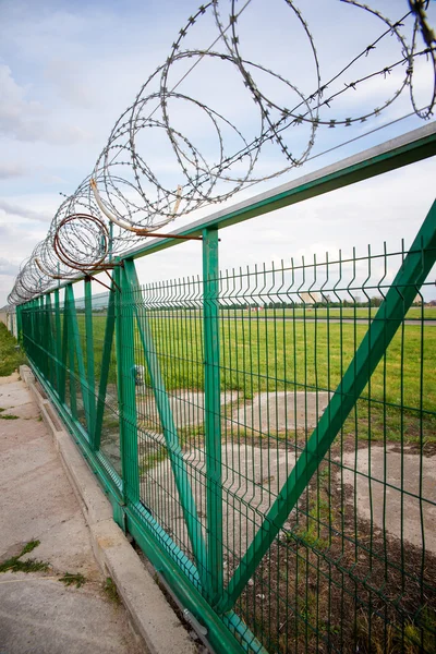 Grönt staket med taggtråd — Stockfoto