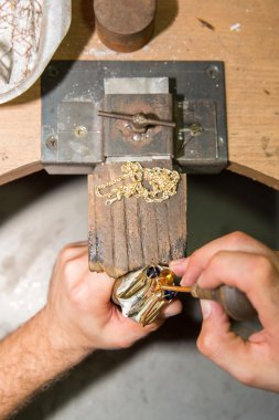 Kuyumcu mücevher altın ürün üzerinde giderir.